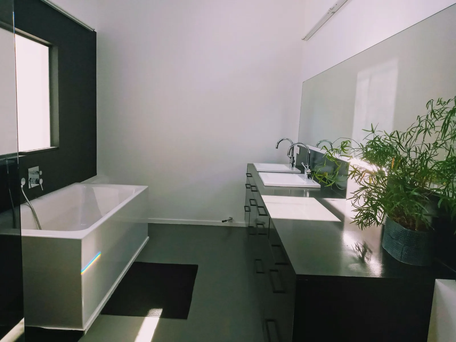 Bathroom with bath and double washbasin in morning light