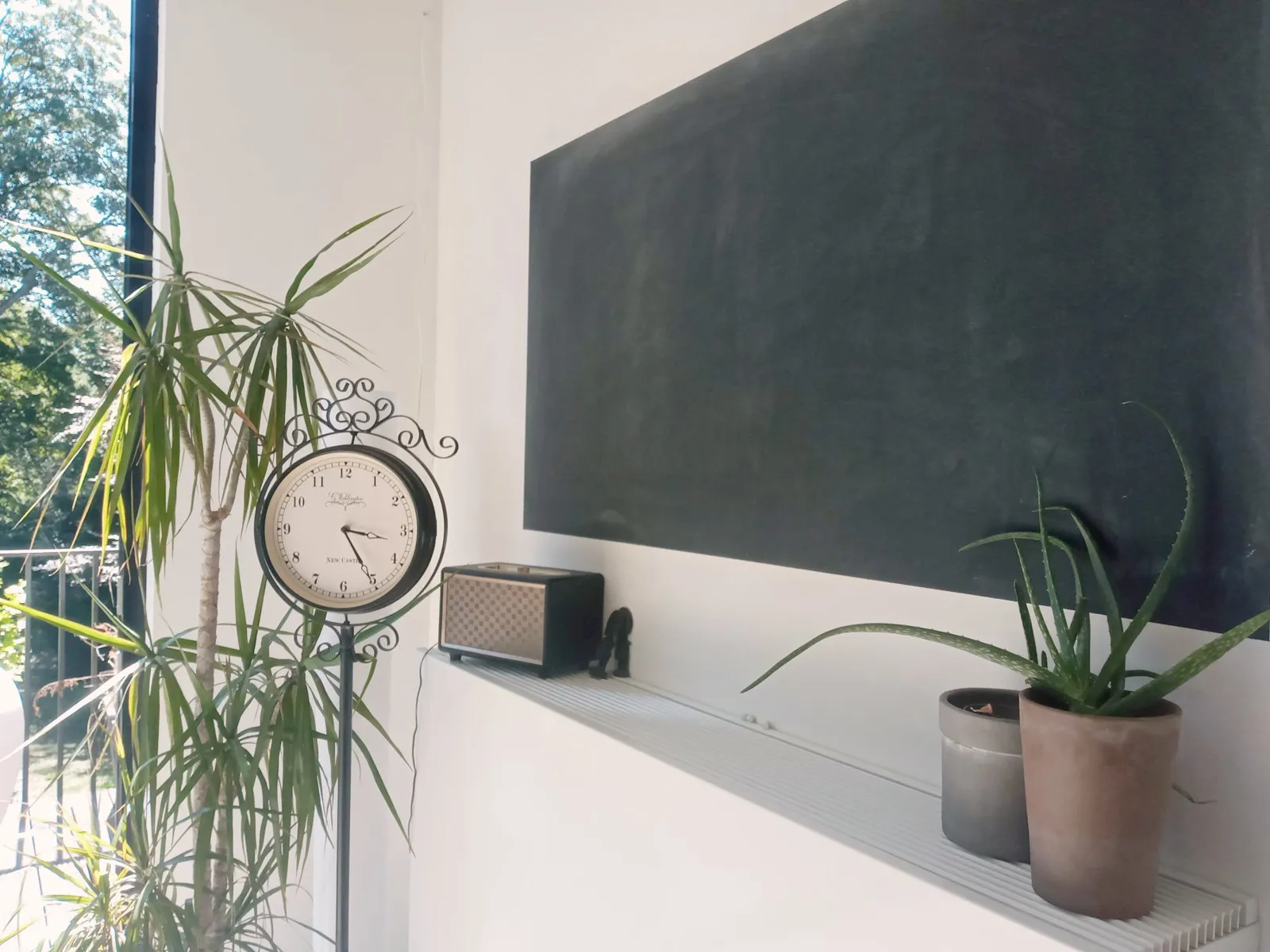 Blackboard wall and station clock by the kitchen window