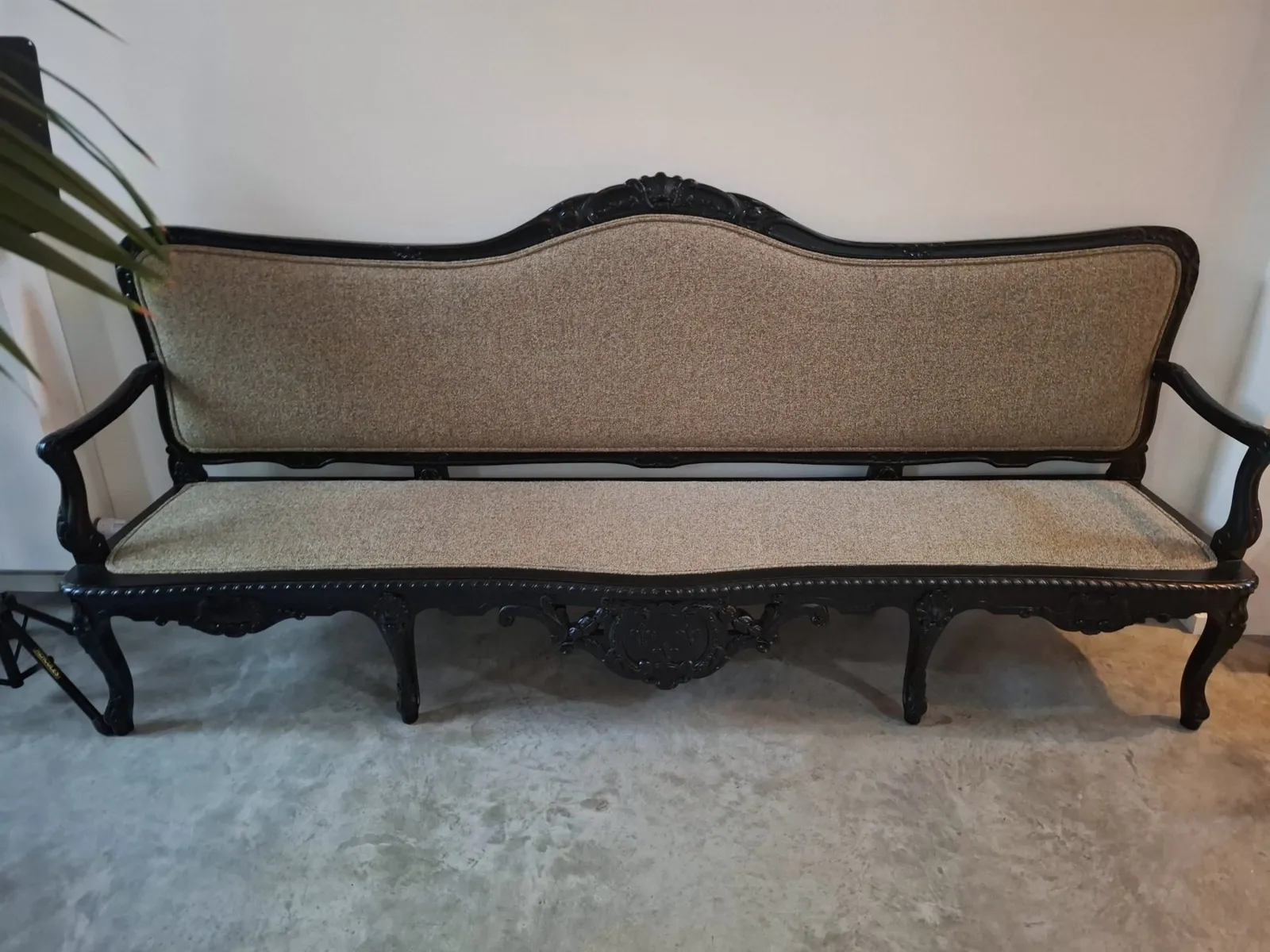 Carved black bench with woven upholstery