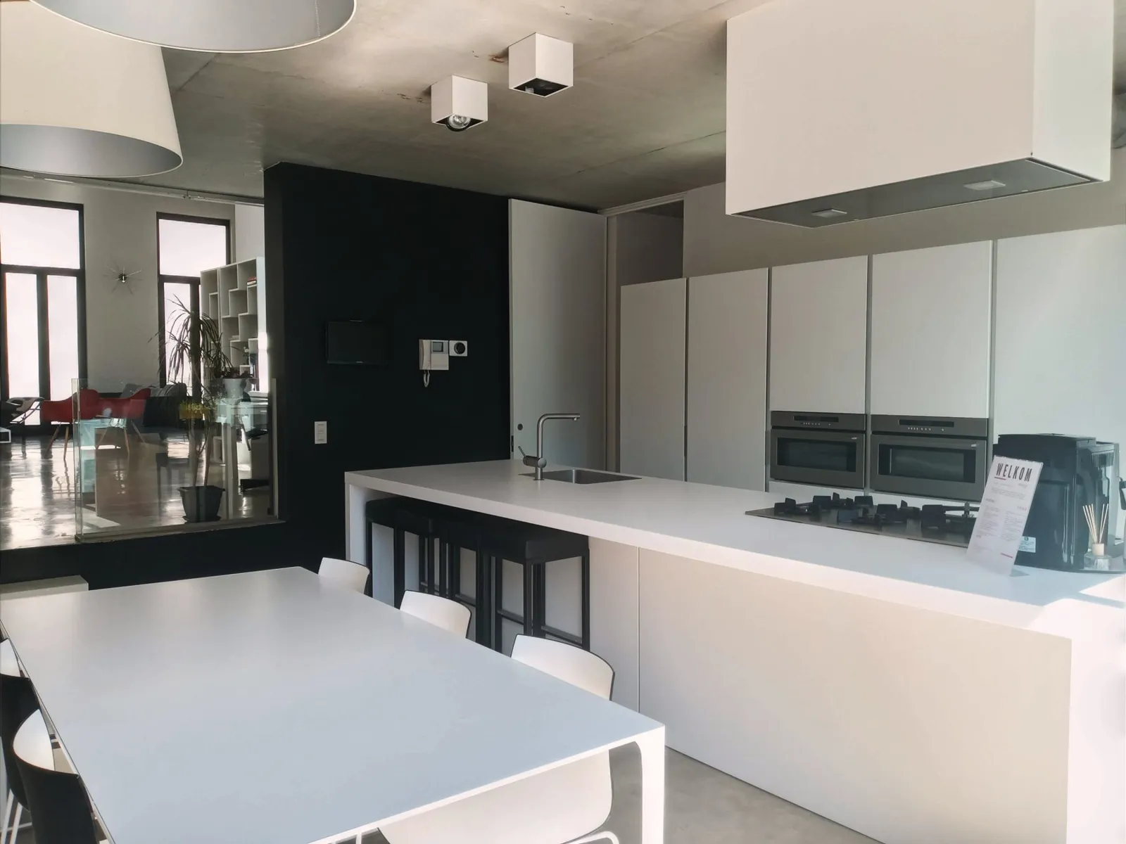The white kitchen island with the dining table in daylight