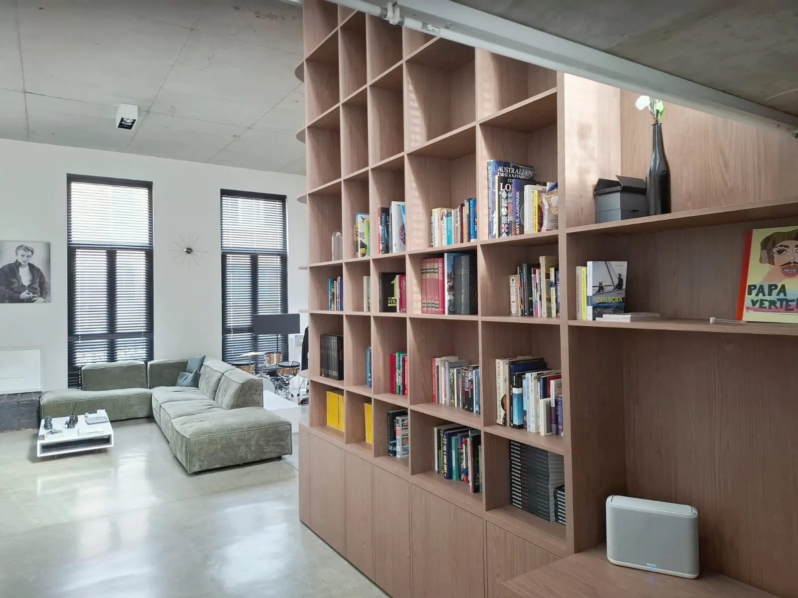 Green corner sofa beside the oak bookcase